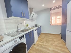 Cocina con horno, vitrocerámica y lavadora en Apartamentos El Sagrario Jaén